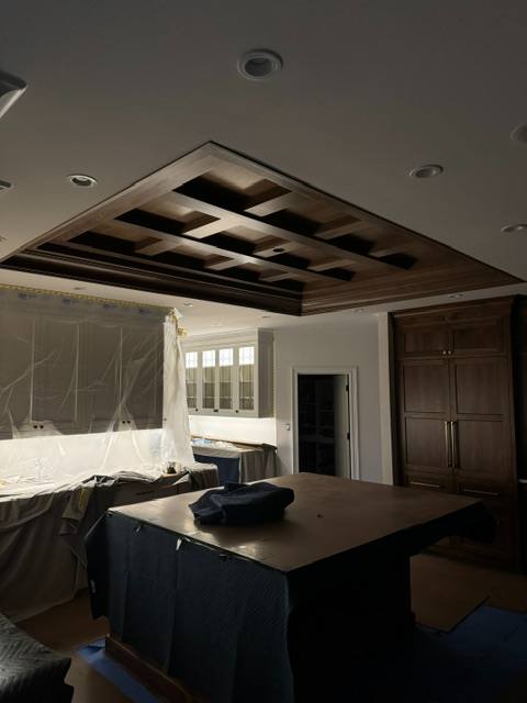 Modern bedroom with geometric wooden ceiling design and dark furnishings