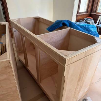 Unfinished wooden cabinet with two compartments and blue fabric visible inside