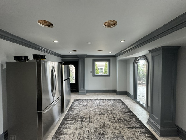 Modern kitchen with stainless steel appliances, gray cabinetry, and glass doors